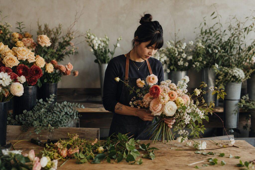 Florist arranging a garden-style bridal bouquet on a workbench