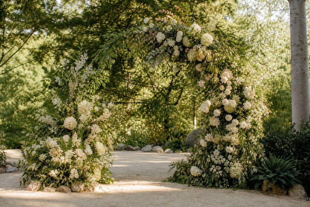 Wedding flower installation ceremony arch wedding flower installation on a ceremony arch with greenery and cream blooms